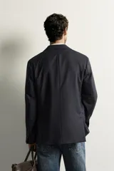 Blazer regular fit de lana azul marino con diseño de rayas sutiles, cuello con solapas de muesca, cierre frontal con botones y bolsillos de parche en la cadera.