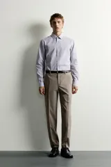 Camisa de corte slim fit con estampado de rayas verticales finas, cuello italiano, manga larga con puños abotonados y cierre frontal de botones.