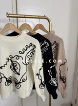 Sweater de tejido de punto con cuello redondo y diseño de bordado lineal en contraste que forma motivos orgánicos y florales. Presenta un corte clásico y mangas largas.