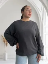 Remera gris topo de tejido acanalado, corte recto y mangas largas.