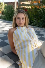 Camisa con cuello halter a rayas amarillas y blancas, con lazos en el frente.