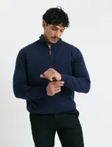 Remera de punto con medio cierre frontal, manga larga, cuello y puños en tejido canalé. Presenta un diseño con cierre metálico y detalle de puller en tono oliva.