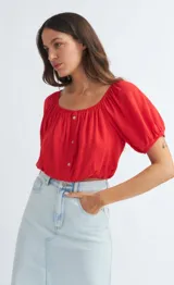 Blusa roja con escote cuadrado, mangas cortas abullonadas y cierre frontal con botones.