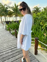 Vestido corto verde manzana de lino, con escote en V con volados y mangas abullonadas.