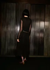 Vestido midi de gasa color negro, con cuello en V, manga larga abullonada y cierre delantero con botones. Incluye forro interior y diseño recto.