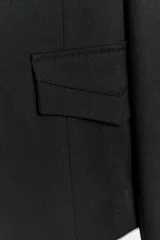 Blazer corto negro de cuello con solapa y manga larga, con hombreras, trabillas en los hombros, falsos bolsillos con solapa en el pecho y en la parte delantera, y cierre frontal con botones.