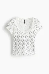 Top corto entallado de manga corta en punto acanalado blanco con estampado floral pequeño, escote redondo y detalles de ribete con encaje en cuello y mangas.