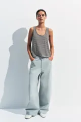 Top musculosa de hilatura con algodón y lino, con diseño de rayas horizontales en color marrón y blanco, escote redondo y manga sisa.