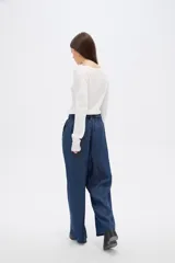Pantalon de lyocell azul oscuro, de corte wide leg y tiro alto. Presenta cintura estilo paper bag con lazo ajustable del mismo tejido y cierre frontal con botón.