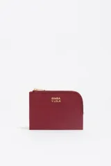 Monedero compacto de Bimba y Lola en color bordó, con cierre de cremallera superior y logo metálico dorado en el frente.