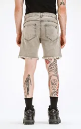 Bermuda de denim rígido, color gris claro con efecto lavado y descolorido. Diseño clásico de cinco bolsillos con ruedo desflecado.