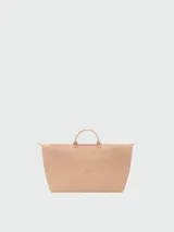 Bolso de viaje de gran tamaño, modelo Le Pliage One de Longchamp, en color marrón. Presenta el diseño icónico de la marca con solapa de cuero, asas cortas y cierre de cremallera superior.