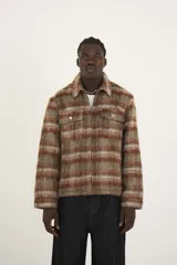 Sobrecamisa estilo chaqueta a cuadros color marrón, con cierre completo y cuello clásico. Incluye bolsillos de solapa en el pecho con detalles de remaches y tachuelas, y un corte ligeramente boxy.