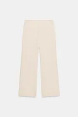Pantalón de corte recto y tiro bajo, color marrón oscuro. Presenta trabillas en la cintura, bolsillos laterales, falsos bolsillos traseros de vivo y raya planchada en el delantero. Cierre frontal con cremallera, botón interior y ganchos metálicos.