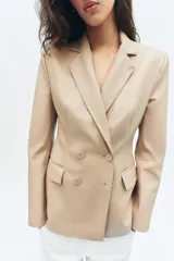Blazer cruzado de efecto piel color bordó, con solapas de muesca, mangas largas y bolsillos con solapa en la parte delantera. Cierre frontal con botones a tono.