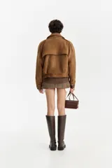 Chaqueta estilo aviador de gamuza color marrón, con cuello solapa ancho y corte holgado.