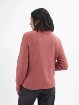Buzo de tejido acanalado color beige, con cuello alto y cierre frontal parcial. Presenta mangas largas y un diseño de calce regular.