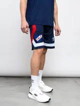 Short de básquet de malla (mesh) azul marino, con detalles en rojo y blanco en los laterales. Presenta el escudo del Club Nacional de Football y el logo de Umbro.