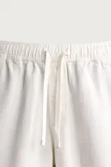 Pantalón de corte regular fit confeccionado en tejido mezcla de algodón, con cintura elástica ajustable mediante cordón, bolsillos laterales y bolsillos traseros de vivo.