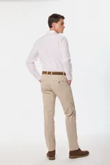 Pantalón de gabardina azul marino de corte slim fit y tiro medio, con bolsillos traseros ojalados con botón y presillas para cinturón.