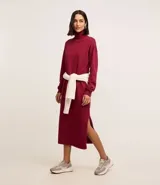 Vestido de punto negro, de manga larga y cuello alto, con corte recto y largo midi.