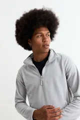 Buzo de polar color bordó, con cuello alto y cierre frontal parcial, de manga larga y diseño funcional con bolsillos laterales.