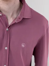 Camisa gris de punto liso para hombre, confeccionada en 100% algodón. Corte regular fit, cuello italiano, manga larga con puño simple y logo bordado en rojo en el pecho.