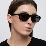 Lentes de sol con montura rectangular de diseño contemporáneo en color verde oliva traslúcido. Presentan cristales oscuros con protección UV.