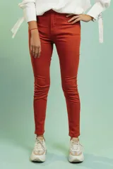 Pantalón tipo jeans de corte chupín y tiro alto, en color terracota.