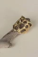 Anillo ancho de diseño orgánico y calado, con apariencia de red o magma solidificado.