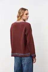 Pullover de punto acanalado en color marrón, con corte oversize, cuello redondo y detalles en contraste en el cuello y los puños.