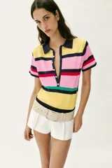 Top de punto de manga corta con cuello polo y cierre frontal de botones, con diseño de franjas horizontales multicolor en tonos amarillo, rosado, azul marino, rojo y verde.