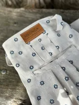 Pantalón de campo color crudo con estampado de pequeñas flores azules, de lino artesanal.