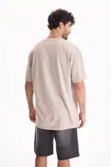 Remera oversize de manga corta y cuello redondo, confeccionada en algodón con acabado lavado estilo vintage.