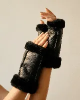 Mitones de cuero negro con interior forrado en corderito sintético, diseño sin dedos con bordes de pelo en las aberturas.