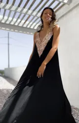 Vestido largo de fiesta color negro, con corte holgado y escote en V profundo decorado con lentejuelas doradas.