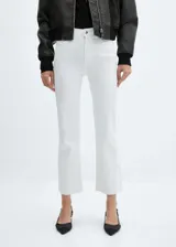 Jeans flare crop blancos de tiro alto, con diseño acampanado y bajo deshilachado. Cuentan con cinco bolsillos, trabillas para cinturón y cierre frontal con cremallera y botón.