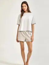 Pijama compuesto por una remera de manga corta en color gris claro y un short con estampado de cuadros en tonos grises y amarillos.