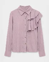 Camisa de manga larga color celeste, con cuello clásico y detalle de volado asimétrico en el frente. Cierre frontal con botones.