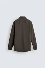 Camisa slim fit de color marrón oscuro, con cuello italiano, manga larga con puños abotonados y cierre frontal de botones. Confeccionada en tejido de fácil cuidado que minimiza la necesidad de planchado.