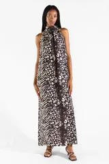 Vestido largo con cuello halter y estampado animal print combinando patrones de leopardo y cebra en tonos negro y crudo. Presenta diseño sin mangas y caída fluida.