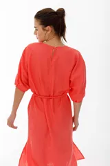 Vestido midi color coral confeccionado en lino. Tiene corte recto, mangas abullonadas con detalle de tablas en el puño, tajos laterales y lazo en la cintura.