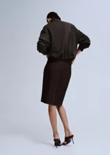 Jersey de manga larga color verde oscuro, con cuello alto y cierre frontal parcial con cremallera.
