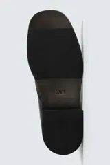 Bota de cuero negro con cordones tipo derby, parte superior lisa y plantilla interior de piel. Presenta horma cuadrada y suela con ligero tacón.