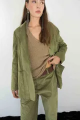 Blazer verde de pana con solapas de muesca, cierre frontal con botones y bolsillos de parche.