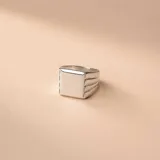 Anillo de plata 925 con diseño de sello cuadrado y detalles estriados en los laterales.