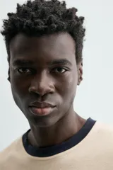 Camiseta de manga corta y cuello redondo, color azul marino, con ribete de contraste en color crema alrededor del cuello.