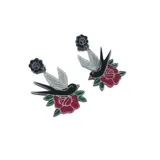 Par de aros colgantes con forma de golondrinas negras con alas plateadas, sobre una rosa roja con hojas verdes.
