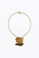 Collar dorado de acero con cadena doble fina y un dije central compuesto por tres piezas metálicas superpuestas de textura machacada.