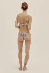 Bombacha de bikini estilo vintage, súper cavada, con estampado de cebra en tonos tierra y negro. Posee terminación embutida para un ajuste cómodo y estilizado.